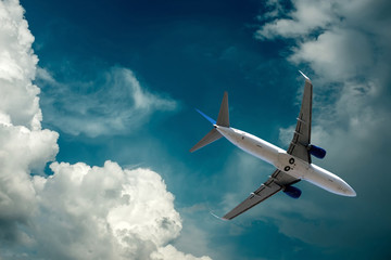 Obraz premium Samolot przy lataniem pod niebem z chmurami