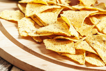 Nachos, tomato sauce, tomatoes, greens, lime on a wooden table,