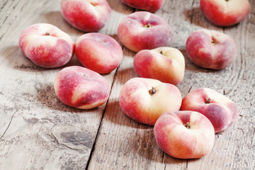 Flat pink peach on an old wooden background, selective focus