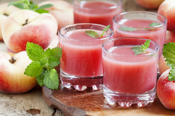 Freshly squeezed pink peach juice in glasses, selective focus