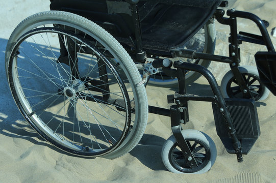 wheelchair stuck in the sand on the seashore