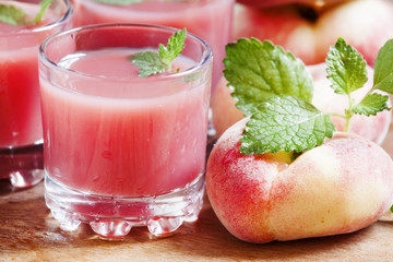 Freshly squeezed pink peach juice in glasses, selective focus
