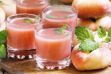 Freshly squeezed pink peach juice in glasses, selective focus