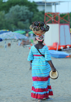 African woman peddler of necklaces and bracelets on the beach