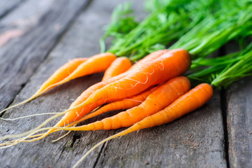 Bunch of fresh washed carrot on the old wooden background