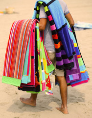 peddler of towels and beach towels on the beach in summer