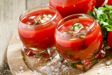 Tomato soup with vegetables in a round glass bowl, selective foc