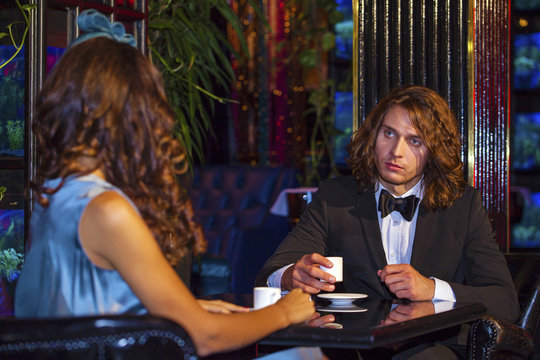 Young couple sitting in a nightclub at the table