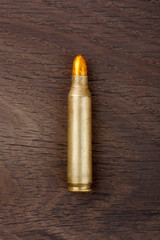 Old rifle bullet on the old wooden desk.