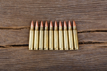 Rifle bullets on wood table.