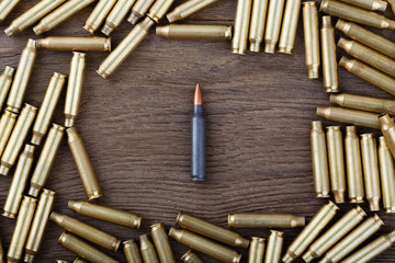 Ak-47 cartridges on wooden table close-up.