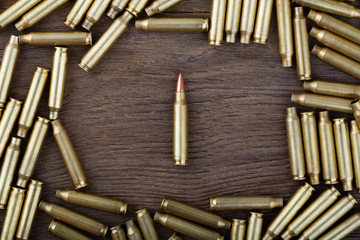 Rifle bullets on wood table with low key scene. Close-up photo.