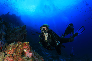 Blonde woman scuba diving on coral reef