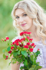 Naklejka premium beauty woman portrait with a bouquet of red roses