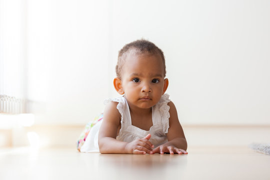Portrait of little African American little girl lying down on th