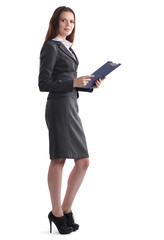 Attractive young businesswoman standing near desk with folder in