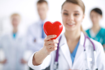 Female doctor with stethoscope holding heart