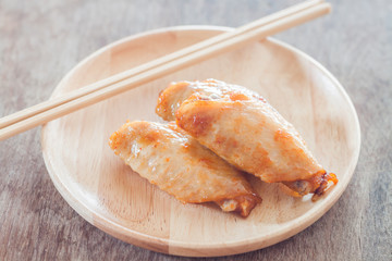 Grilled chicken wings on wooden plate