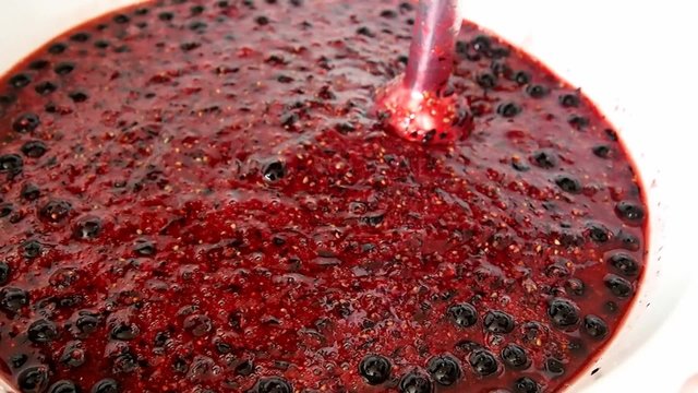 Woman makes jam with blackcurrants