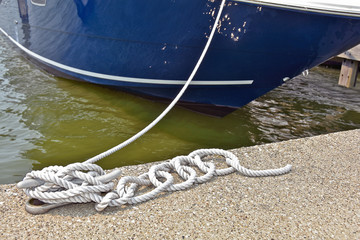 nautical rope securing boat in marina slip