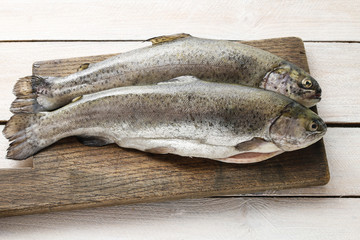 Two rainbow trouts on rustic wooden table