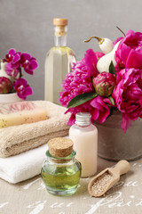 Fototapeta na wymiar Spa set: bottles of liquid soap and essential oil, soft towels a
