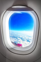 Fototapeta premium Airplane Porthole Window and Summer Clouds