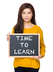 Woman with chalkboard showing phrase of time to learn