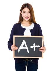 Asian woman with chalkboard showing A plus mark