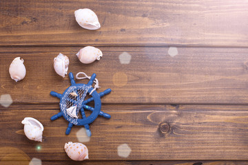 Decorative helm and marine items on wooden background.