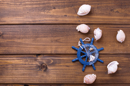 Decorative helm and marine items on wooden background.