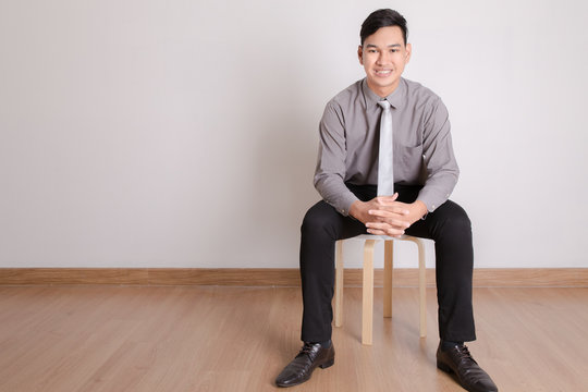 Asian business man sitting on a chair over white background