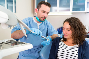 Young attractive dentist explaning his work to a patient
