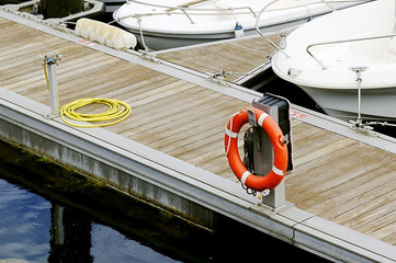 pier with boats, hose and  ring buoy