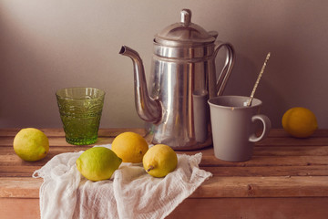 Lemons and tea pot on wooden table. Vintage rustic still life