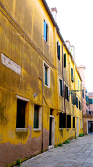 Alley with ancient yellow decay wall building