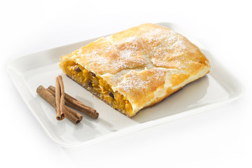 pumpkin strudel on a plate on a table with a cinnamon