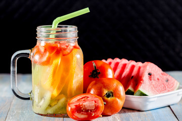 citrus fruits and kiwi, tomato in pitcher