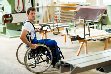 Fototapeta na wymiar worker in wheelchair in a carpenter's workshop