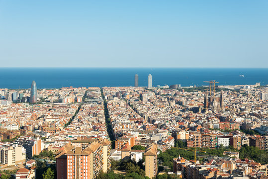 The Torre Agbar in the Barcelona district Poblenou. The Sagrada Familia in the district Eixample. In the middle, in the background, the towers of the Port Olimpic