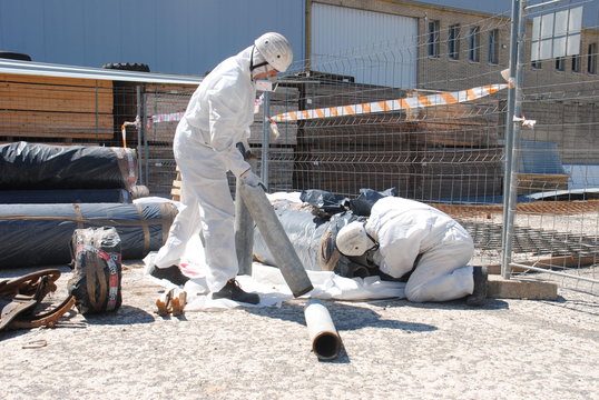 Trabajadores de amianto meten tuberías de fibrocemento dentro de sacos especiales-1