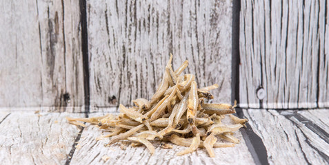 Raw anchovies over rustic wooden background