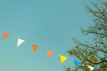 colorful festive bunting flags against a blue sky background