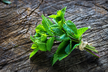 Bunch of freshly picked Mentha  on a wooden background © Daniel Vincek