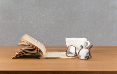 old book with glasses and a cup of coffee