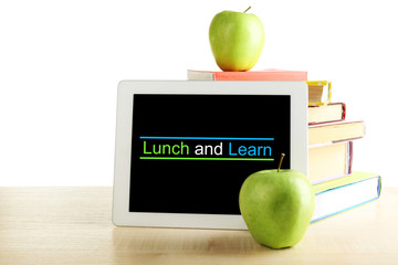 Books, PC tablet and apple on desk, isolated on white