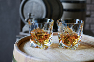 Glasses of brandy in cellar with old barrels