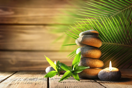 Spa stones, candle on wooden background