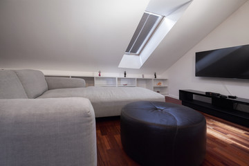 Fototapeta premium Corner grey sofa in attic