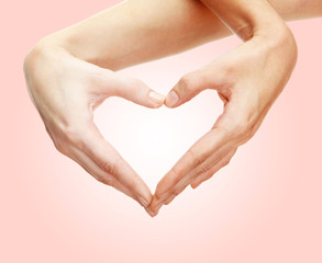 Obraz premium Hands in shape of heart on light background